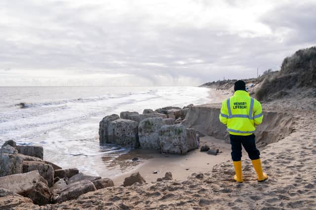 Members of the Hemsby Lifeboat crew inspect the eroded dunes at Hemsby in Norfolk. Picture: PA 