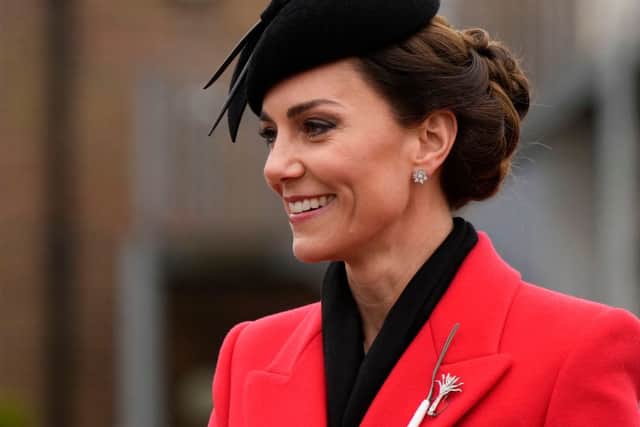 Kate Middleton dazzled in a leek brooch and red Alexander McQueen coat for St David's Day. Photo by ALASTAIR GRANT/POOL/AFP via Getty Images)

