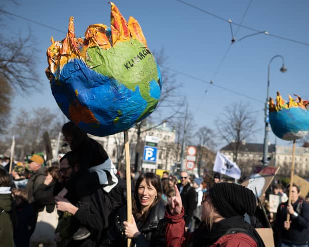 Supporters of the Fridays for Future climate action movement hold up a model of earth burning during the 3 March global strike in Vienna  (Photo by Thomas Kronsteiner/Getty Images).