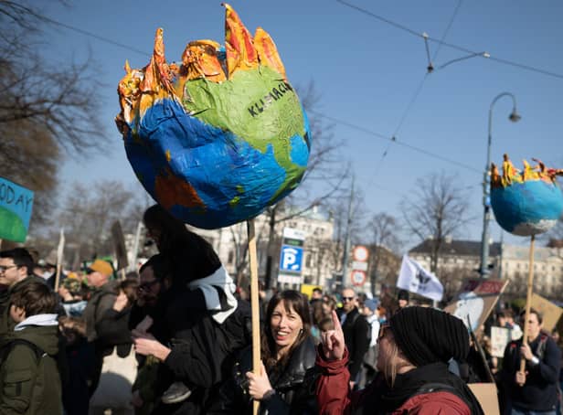 Supporters of the Fridays for Future climate action movement hold up a model of earth burning during the 3 March global strike in Vienna  (Photo by Thomas Kronsteiner/Getty Images).