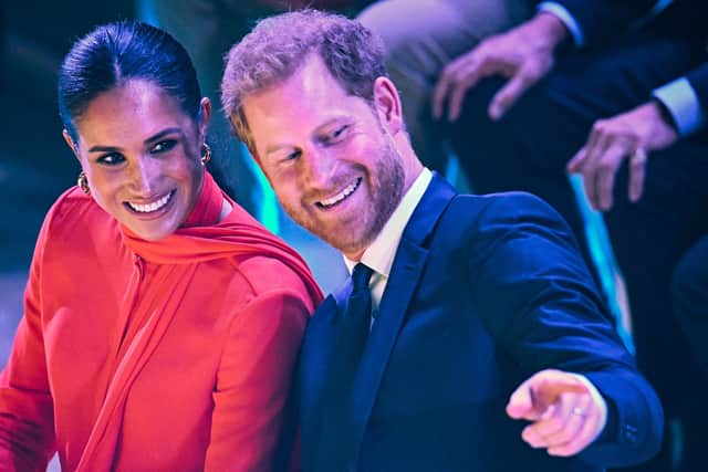 Britain's Meghan, Duchess of Sussex (L) and Britain's Prince Harry, Duke of Sussex, react as they attend the annual One Young World Summit at Bridgewater Hall 