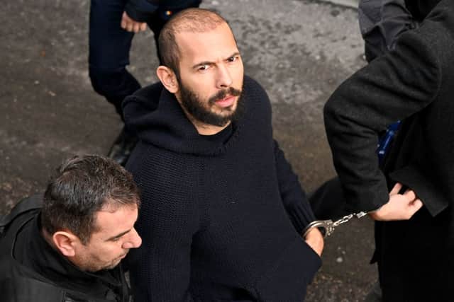 British-US influencer Andrew Tate arrives handcuffed and escorted by police at a courthouse in Bucharest on February 1, 2023 (Photo by DANIEL MIHAILESCU/AFP via Getty Images)