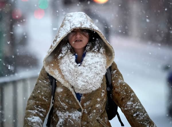 A woman makes her way through a snow flurry in Cheshire in December 2022 (Photo: Christopher Furlong/Getty Images)