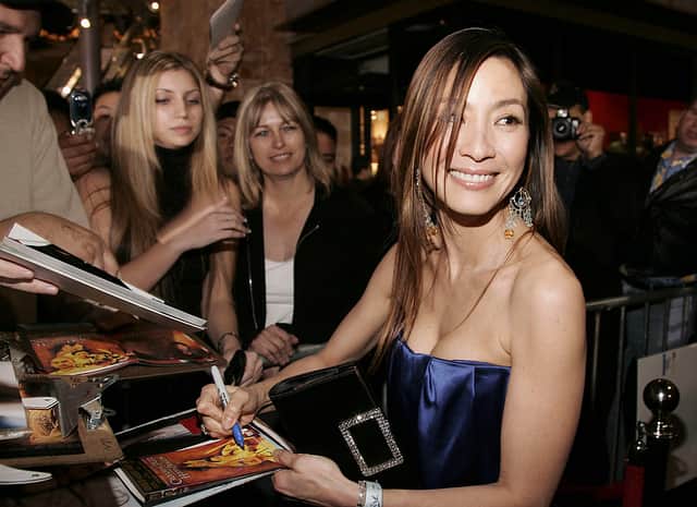 Actress Michelle Yeoh signs autographs for fans at the Los Angeles premiere of Columbia Pictures’ “Memoirs of a Geisha” on December 4, 2005 at The Kodak Theatre in Hollywood, California. (Photo by Vince Bucci/Getty Images)