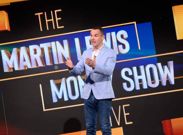 Martin Lewis pictured on set of The Martin Lewis Money Show, gesturing to the audience with his logo behind him (Credit: Multistory Media/Jonathan Hordle/ITV)