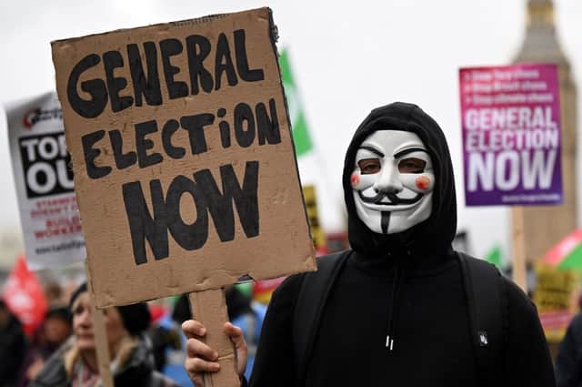 Demonstrators with placards calling for a General Election march near the Houses of Parliament in central London, during a a national demonstration on November 5, 2022, calling for a General Election (Photo by JUSTIN TALLIS/AFP via Getty Images)