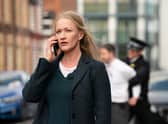 Paula Malcolmson as DCI Collette Cunningham in Redemption, taking a phone call as an arrest is carried out behind her (Credit: ITV)