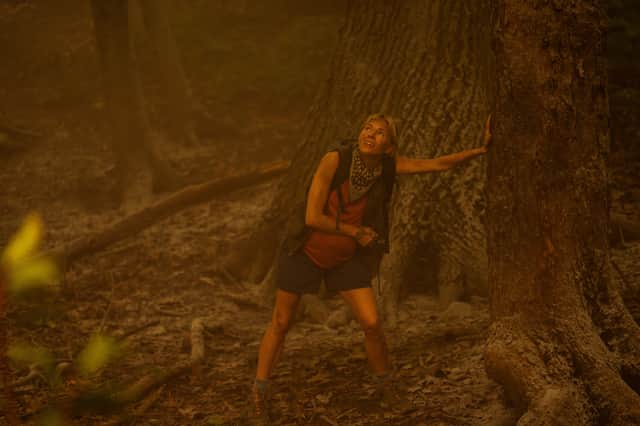 Sienna Miller as Rebecca Shearer in Extrapolations, leaning against a tree during a forest fire (Credit: Apple TV+)