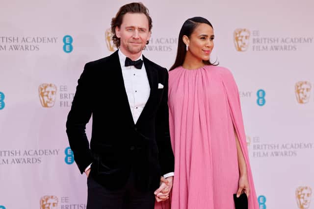 British actor Tom Hiddleston (L) and British actress Zawe Ashton pose on the red carpet upon arrival at the BAFTA British Academy Film Awards at the Royal Albert Hall, in London, on March 13, 2022. (Photo by Tolga Akmen / AFP) 
