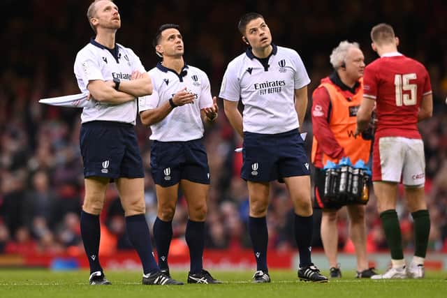 Referee Nic Berry makes a decision whilst looking at the TMO with assistants Wayne Barnes (l) and Chris Busby during the Guinness Six Nations match between Wales and Scotland at Principality Stadium on February 12, 2022 in Cardiff, Wales. (Photo by Stu Forster/Getty Images)