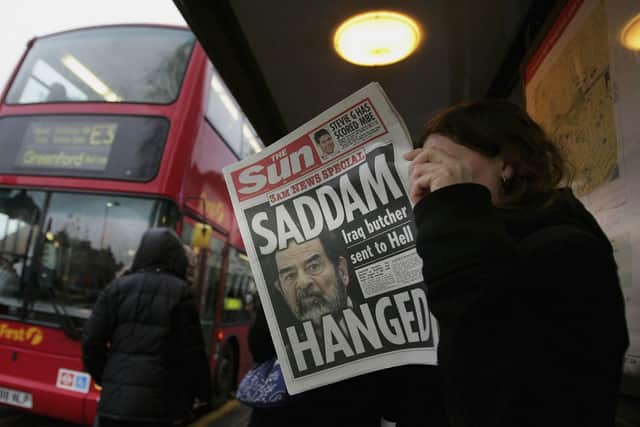 A woman reads a  newspaper at a bus stop with a headline of the death of former Iraqi president Saddam Hussein on December 30, 2006 in London (Photo: Scott Barbour/Getty Images)