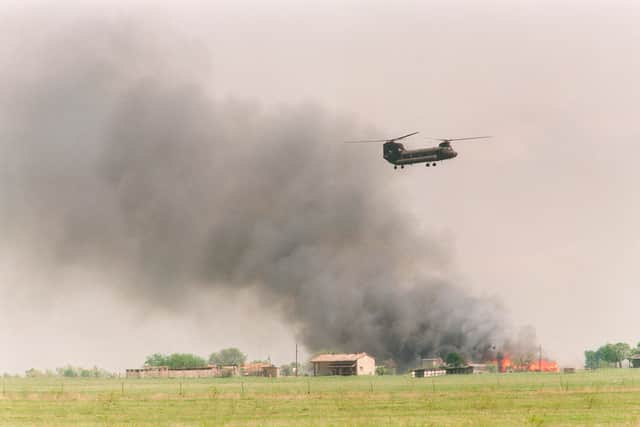 A National Guard helicopter flies past the burning Branch Davidian compound in Waco, Texas (Photo: TIM ROBERTS/AFP via Getty Images)