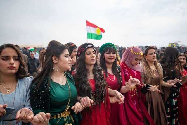Women dance during a Syrian Kurdish celebration marking their Nowruz New Year, on March 21, 2022. (Photo by DELIL SOULEIMAN/AFP via Getty Images)