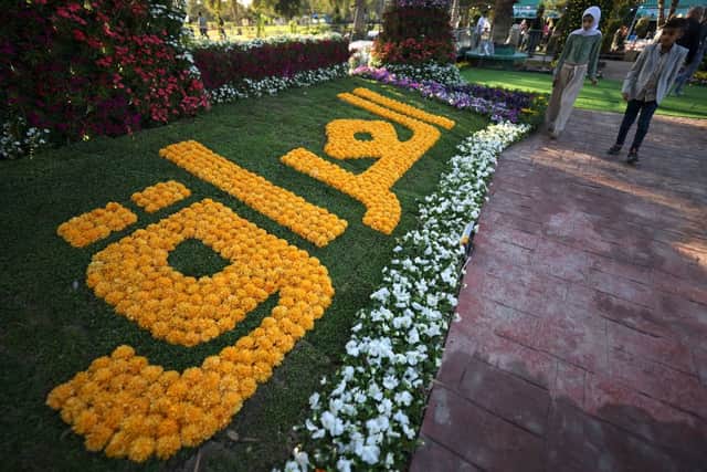 Visitors walk by flower art exhibits during the Baghdad International Festival of Flowers and Gardens organised to mark Nowruz celebrations symbolising the beginning of spring, at the al-Zawraa Zoo in Baghdad on March 16, 2023. (Photo by AHMAD AL-RUBAYE/AFP via Getty Images)