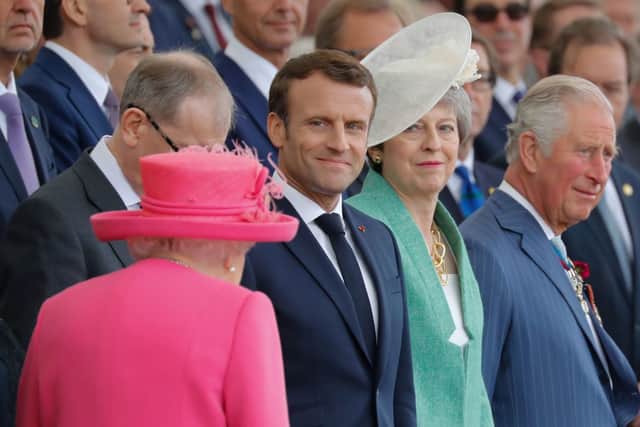 French President Emmanuel Macron react as Britain's Queen Elizabeth II (L) arrives to attend an event to commemorate the 75th anniversary of the D-Day landings, in Portsmouth, southern England, on June 5, 2019. (Photo credit: TOLGA AKMEN/AFP via Getty Images)