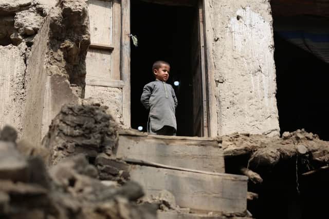A boy looks out from his damaged home in Miya village, in the Laghman Province on after ab  overnight earthquake that has killed at least 13 people (Photo by SHAFIULLAH KAKAR/AFP via Getty Images)