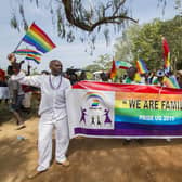 People hold a banner reading “We are Family” while waving rainbow flags as they take part in the Gay Pride parade in Entebbe, Uganda, on August 8, 2015. (Photo: ISAAC KASAMANI/AFP via Getty Images)