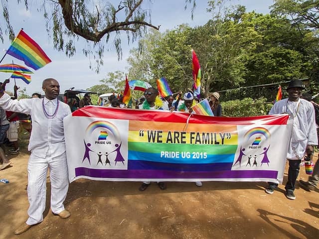 People hold a banner reading “We are Family” while waving rainbow flags as they take part in the Gay Pride parade in Entebbe, Uganda, on August 8, 2015. (Photo: ISAAC KASAMANI/AFP via Getty Images)