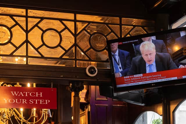 People sit in the Red Lion pub in London as former Prime Minister Boris Johnson giving evidence on Partygate is shown on the TV on 22 March 2023 (Photo: Dan Kitwood/Getty Images)