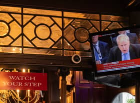 People sit in the Red Lion pub in London as former Prime Minister Boris Johnson giving evidence on Partygate is shown on the TV on 22 March 2023 (Photo: Dan Kitwood/Getty Images)