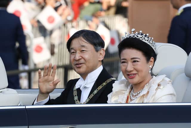 Emperor Naruhito and Empress Masako wave from their car during the imperial parade for enthronement of Emperor Naruhito on November 10, 2019 in Tokyo, Japan. Japan's Emperor Naruhito and Empress Masako paraded in a convertible sedan along a 4.6-kilometer route in Tokyo from the Imperial Palace to their residence in the Akasaka Estate to mark the enthronement. (Photo by Takashi Aoyama/Getty Images)