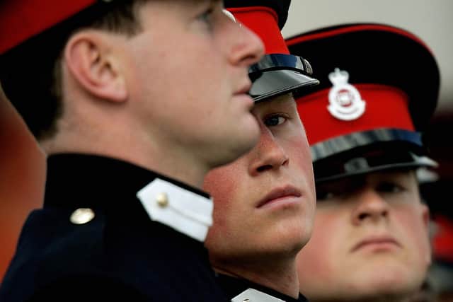 Sandhurst, UNITED KINGDOM:  Britian's Prince Harry (2nd L) marches during the Sovereign's Parade at the Royal Military Academy in Sandhurst, southern England, April 12, 2006. Officer Cadet H Wales as Prince Harry is known, will train to become a troop commander, in charge of 11 enlisted men and four light tanks -- a job that could soon see him on front-line duty in Iraq or Afghanistan. His grandmother Queen Elizabeth II, who turns 80 on April 21, and father Prince Charles both turned out for the passing-out ceremony where Harry and 218 other officer cadets in crisp blue uniforms, each carrying thin silver swords, received their commissions after 44 weeks of gruelling training. AFP PHOTO/Dylan Martinez / Pool  (Photo credit should read DYLAN MARTINEZ/AFP via Getty Images)