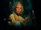 Olivia Colman as Miss Havisham in Great Expectations, holding a candle (Credit: BBC/FX Networks/Pari Dukovic)