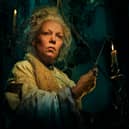 Olivia Colman as Miss Havisham in Great Expectations, holding a candle (Credit: BBC/FX Networks/Pari Dukovic)