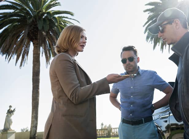 Sarah Snook as Shiv, Kieran Culkin as Roman, and Jeremy Strong as Kendall Roy in Succession Season 4, taking a phone call beneath some palm trees (Credit: HBO)