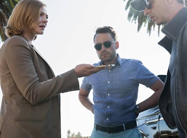 Sarah Snook as Shiv, Kieran Culkin as Roman, and Jeremy Strong as Kendall Roy in Succession Season 4, taking a phone call beneath some palm trees (Credit: HBO)