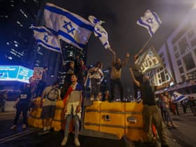 Israeli protesters wave national flags on a barricade as they block a road during a rally against the government’s controversial judicial overhaul bill in Tel Aviv. Picture: AHMAD GHARABLI/AFP via Getty Images