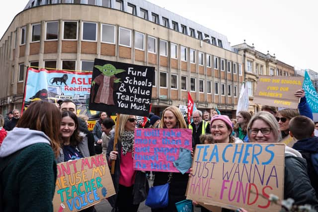 Teachers and members of the National Education Union (NEU) hold placards during a demonstration called by the NEU trade unions in the streets of Reading, on February 1, 2023 during a national strike day