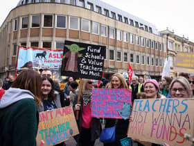 Teachers and members of the National Education Union (NEU) hold placards during a demonstration called by the NEU trade unions in the streets of Reading, on February 1, 2023 during a national strike day