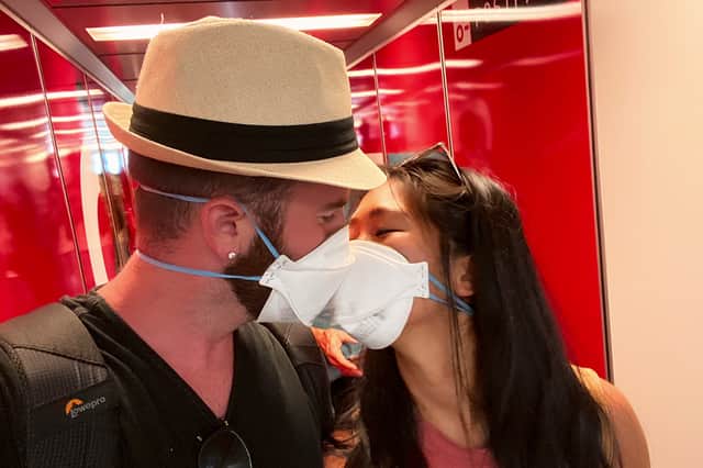 Matt Robertson and Khani Le in Longest Third Date, kissing through face masks (Credit: Netflix)