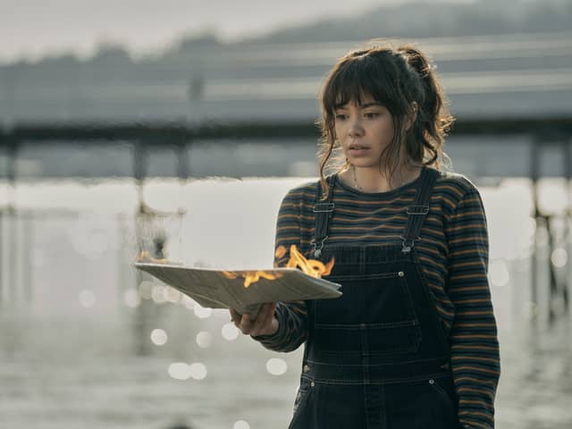 Auli'i Cravalho as Jos Cleary-Lopez in The Power, holding a piece of paper on fire in her hands (Credit: Katie Yu/Prime Video)