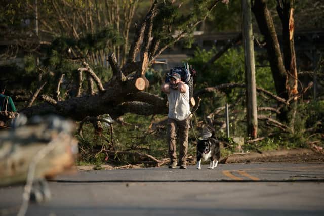 A resident and their pet evacuate from their neighborhood damaged by a tornado on March 31, 2023 in Little Rock, Arkansas.  (Photo by Benjamin Krain/Getty Images)