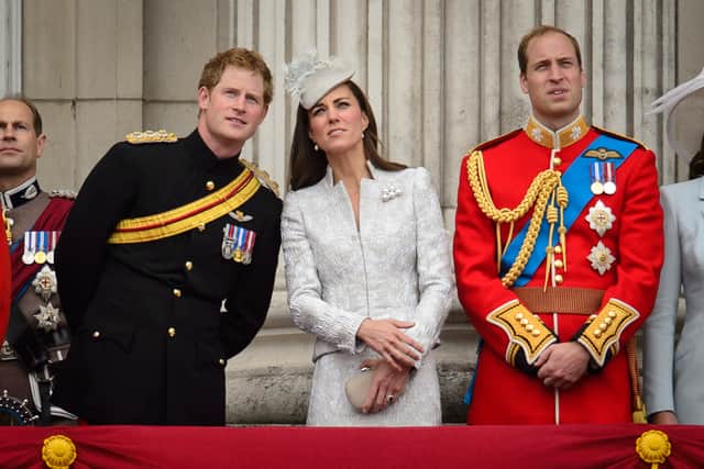 (L-R) Britain's Prince Harry, Catherine, Duchess of Cambridge, and Prince William, Duke of Cambridge, watch the fly-past as they stand on the balcony of Buckingham Palace following the Trooping the Colour - Queen Elizabeth II's Birthday Parade, at The Royal Horseguards in London on June 14, 2014. The ceremony of Trooping the Colour is believed to have first been performed during the reign of King Charles II. In 1748, it was decided that the parade would be used to mark the official birthday of the Sovereign. More than 600 guardsmen and cavalry make up the parade, a celebration of the Sovereign's official birthday, although the Queen's actual birthday is on 21 April. AFP PHOTO / LEON NEAL (Photo by LEON NEAL / AFP) (Photo by LEON NEAL/AFP via Getty Images)