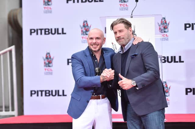 Rapper Pitbull and actor John Travolta are pals.