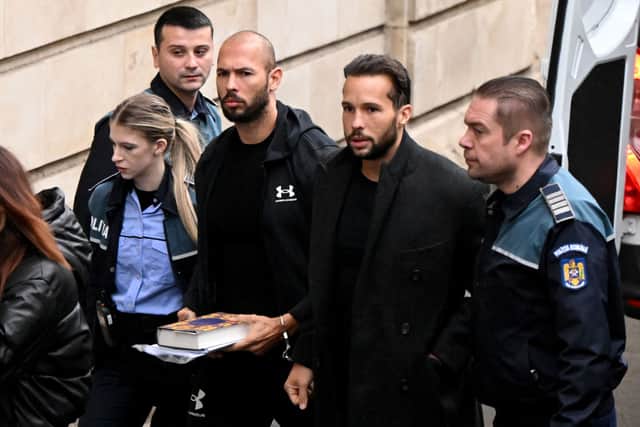 British-US former professional kickboxer and controversial influencer Andrew Tate (3rd R) and his brother Tristan Tate (2nd R) arrive handcuffed and escorted by police at a courthouse in Bucharest on January 10, 2023 for a court hearing on their appeal against pre-trial detention for alleged human trafficking, rape and forming a criminal group. Credit: Getty Images