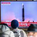 People sit near a television showing a news broadcast with file footage of a North Korean missile test in Seoul (Photo: ANTHONY WALLACE/AFP via Getty Images)