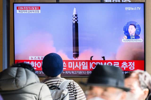 People sit near a television showing a news broadcast with file footage of a North Korean missile test in Seoul (Photo: ANTHONY WALLACE/AFP via Getty Images)