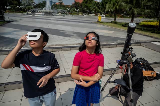 Children watch the solar eclipse in the Indonesian city of Surabaya (Photo: JUNI KRISWANTO/AFP via Getty Images)