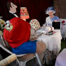 A life size cardboard cut out of Queen Elizabeth II with Paddington Bear seated at a table for tea is on display at the Rose Tree Cottage English Tea Room in Pasadena, California, following the death of the Queen on September 8, 2022. - Admirers of the head of the British throne for more than 70 years are mourning their beloved monarch, the longest serving in Britain's history, paying their respects from around the world. (Photo by Robyn Beck / AFP) (Photo by ROBYN BECK/AFP via Getty Images)