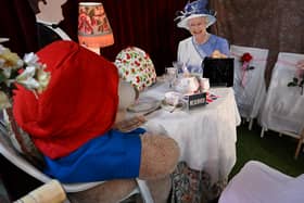 A life size cardboard cut out of Queen Elizabeth II with Paddington Bear seated at a table for tea is on display at the Rose Tree Cottage English Tea Room in Pasadena, California, following the death of the Queen on September 8, 2022. - Admirers of the head of the British throne for more than 70 years are mourning their beloved monarch, the longest serving in Britain's history, paying their respects from around the world. (Photo by Robyn Beck / AFP) (Photo by ROBYN BECK/AFP via Getty Images)
