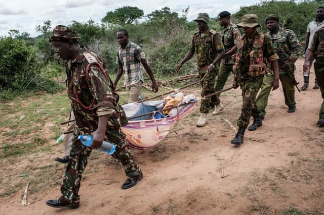 Security personnel carry a rescued young person from the forest in Shakahola, outside the coastal town of Malindi - Credit: Getty Images