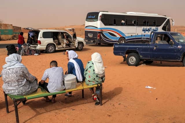 People fleeing the conflict in Khartoum stop for refreshments at a rest-point by a desert road about 100 kilometres northwest of the capital (Photo: AFP via Getty Images)