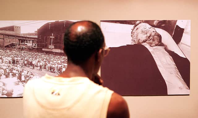 Leon Smith examines photographs from the funeral of Emmett Till at the Chicago Historical Society June 13, 2005 in Chicago, Illinois. (Photo by Scott Olson/Getty Images)