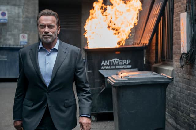 Arnold Schwarzenegger as Luke Brunner in Fubar, walking away from a small explosion (Credit: Christos Kalohoridis/Netflix)