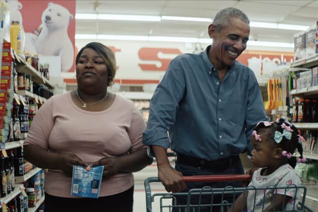 President Obama bothers a woman and her young daughter while grocery shopping in a scene from Working: What We Do All Day (Credit: Netflix)