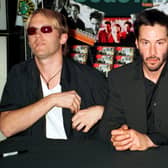 Actor Keanu Reeves, center, poses for photographers, July 11, 2000, with fellow band members of Dogstar, vocalist/guitarist Bret Domrose ,left, and drummer Rob Mailhouse ,right, at an in-store signing for their new cd at Coconuts Music Stores in New York City. (Photo by George De Sota/Liaison)